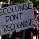 Aboriginal protesters hold banners and chant slogans during a protest outside a government office building in Sydney, Australia